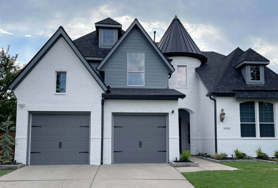 Florida Home Stamped carriage house garage doors in graphite modern tudor style